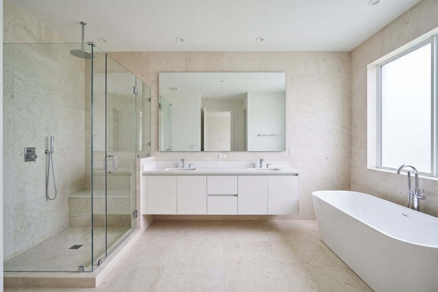 Bare bathroom before virtual staging - glass shower, double vanity, freestanding tub, marble tile