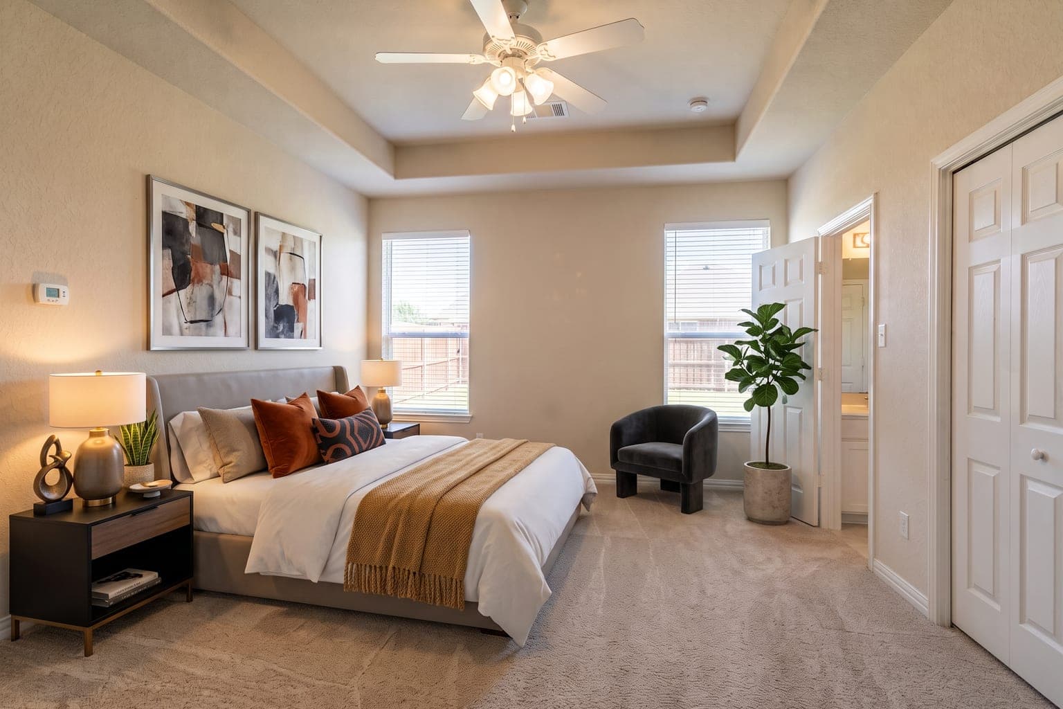 Primary bedroom virtually staged with AI in Creative mode - upholstered bed, reading chair, gallery art and a fiddle-leaf fig