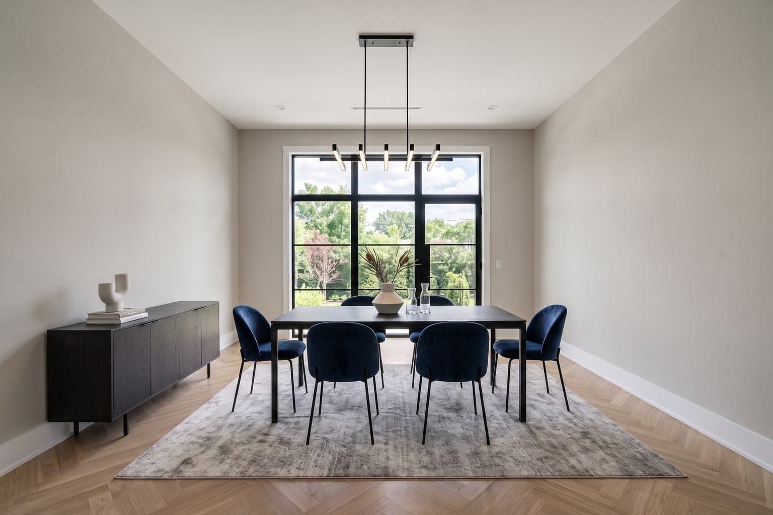 Dining room virtually staged with AI in contemporary style - dark wood table, navy chairs, credenza and rug