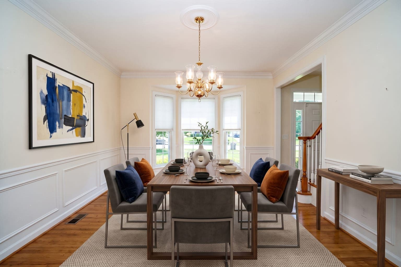 Dining room virtually staged with AI in contemporary style - walnut table, upholstered chairs, console and abstract art
