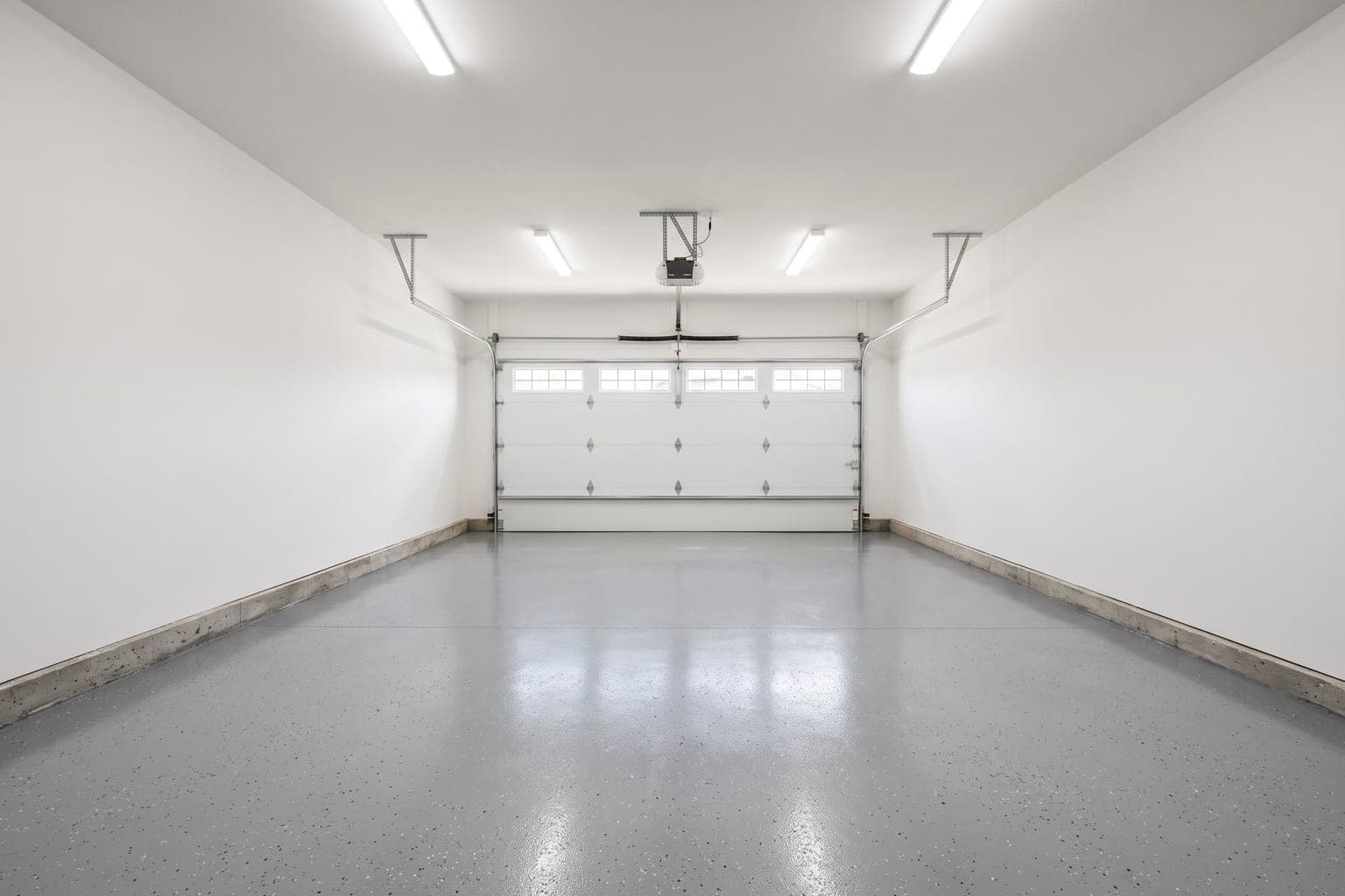 Empty two-car garage before virtual staging - epoxy floor, white walls, garage door with windows